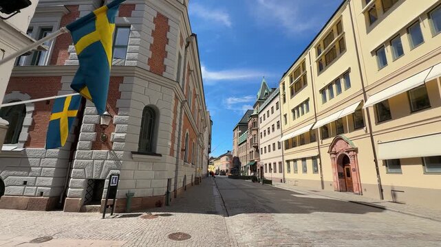 Historic architecture on cobblestone street with Swedish flags in Malmo, Sweden