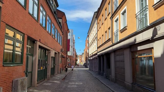 Narrow cobblestone street with historic buildings in Malmo city, Sweden