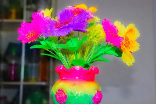 A cheap plastic flower in a garish vase, tacky aesthetic with bright colors.