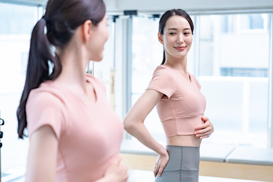 鏡でお腹をチェックする女性