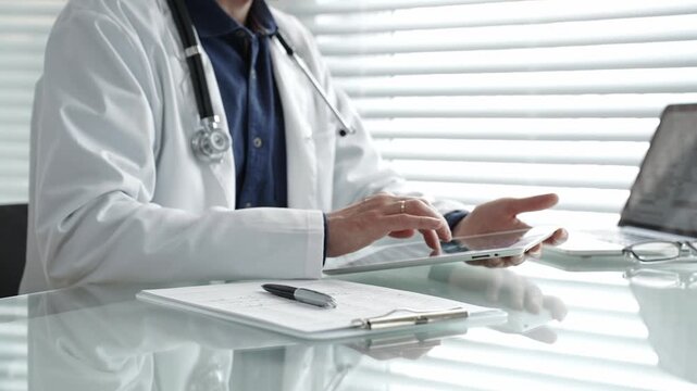 Doctor taking notes on a clipboard and holding a digital tablet, combining traditional paperwork with modern technology in healthcare for patient record management and medical consultation