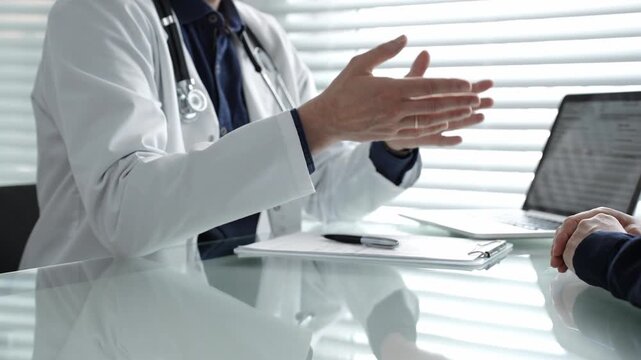 Doctor discussing medical information and treatment options with patient in a clinic, providing professional healthcare consultation and modern diagnostic services