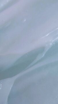 Close up of smoothing wavy soft white cream. Beauty product cream being stirred with a tool. Skincare texture concept for daily treatment.