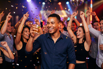 Obraz premium Group of joyful friends celebrating with drinks and confetti in a nightclub