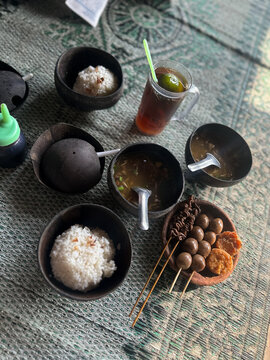 Traditional Indonesian Soto Batok Soup Served in Coconut Shells with Sides