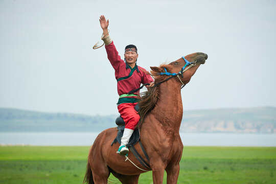 Mongolian men on horseback at the Naadam Festival on the grassland