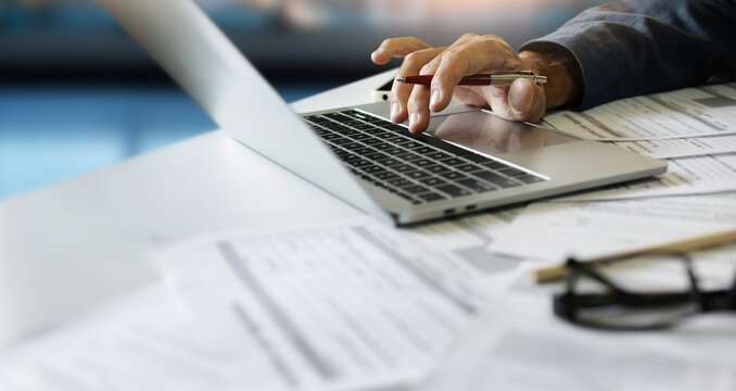 close-up shot, man hand using laptop working on desk with document and meeting online via wireless technology