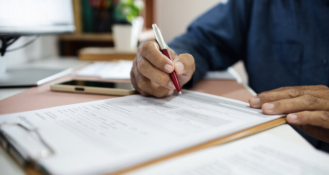close-up shot, businessman work on desk reviewing business contract and verify the accuracy of the document