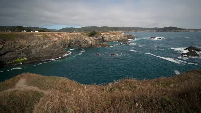 Witness the beauty of Mendocino California along the Pacific Ocean with views of rugged cliffs and clear waters on a cloudy day