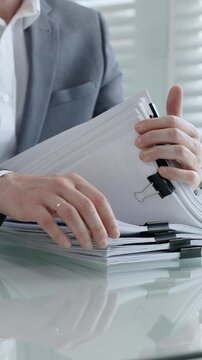 Business professional hands actively managing a large stack of office documents. Reports. And paperwork. Representing administrative work. Corporate bureaucracy