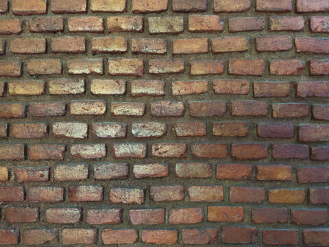 Brick wall with different shades of red and brown in a building setting