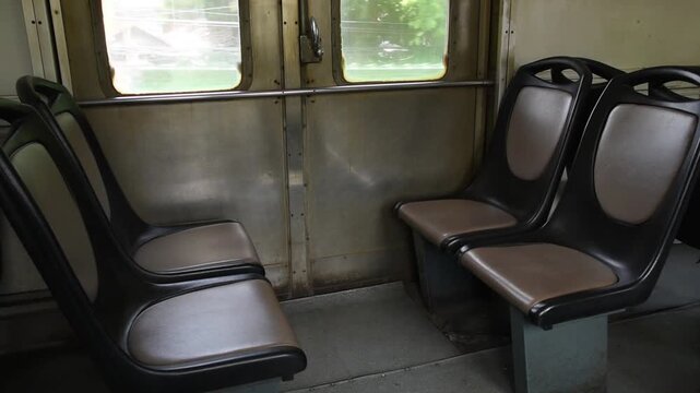 empty retro seats next to closed side door inside moving passenger train