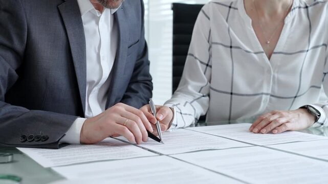 Business people discussing contract details, negotiating terms and conditions, reviewing legal documents, making financial decisions during a corporate meeting or consulting session