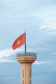 Vietnamese national flag waving proudly on the flagpole of Ly Son Island under a clear blue sky