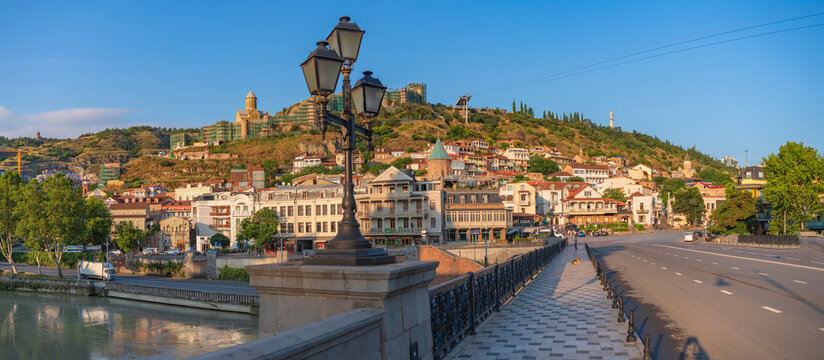 Old Tbilisi city panorama from Metekhi bridge at sunrise with copy space