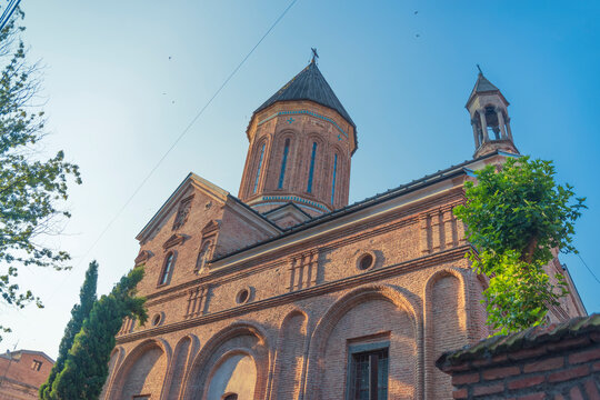 Ancient Surb Gevorg brick church facade in old Tbilisi with sky copy space