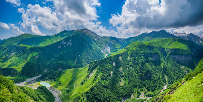 Epic green Caucasus mountain valley with turquoise lake in Georgia with copy space