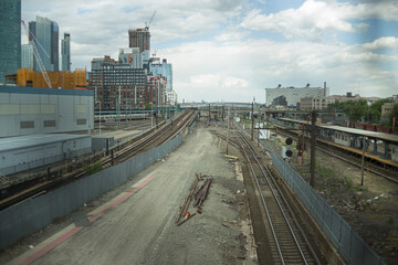 Obraz premium Wide high-angle view of an urban rail yard and train tracks leading into a city skyline
