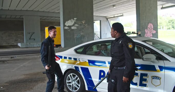 Police Officers Actively Engaging with Citizens in an Urban Underpass Area Facility