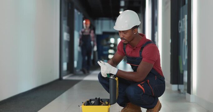 A Skilled Worker Dressed in Safety Gear is Actively Engaged Working with Various Tools