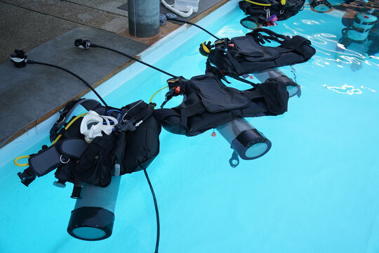 Scuba diving equipment with oxygen tank near swimming pool