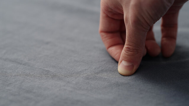 man manually check gray blue color cotton fabric for clothing with hands