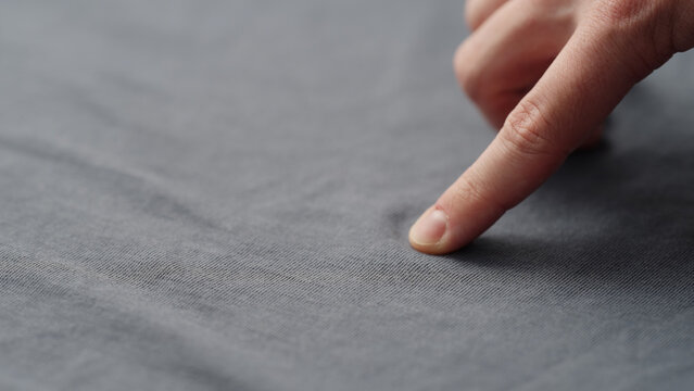 man manually check gray blue color cotton fabric for clothing with hands