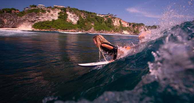 Blonde Female Surfer Paddling Through Turquoise Waves Near Lush
