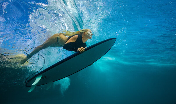 Aquatic Action Shot of Surfer Gliding Under Bright Blue Ocean Wa