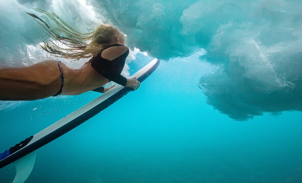 Dynamic Underwater Shot Of Female Surfer Riding Cresting Wave
