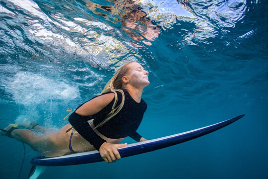 Tranquil Underwater View of Female Surfer Floating Near Surface