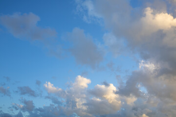 Obraz premium Bright Blue Sky with Large White Cumulus Clouds. Scenic view of large cumulus clouds floating across a bright blue sky. Perfect natural background representing peaceful weather and fresh summer air.