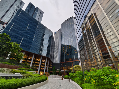 Ground level plaza with columned entrance, inviting steps and greenery frame office lobby.
