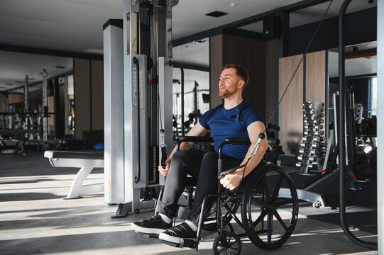 Man with disability, athlete doing rehabilitation exercises with cable machine in gym