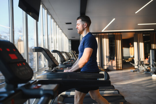 Man doing rehabilitation exercises walking on treadmill in gym