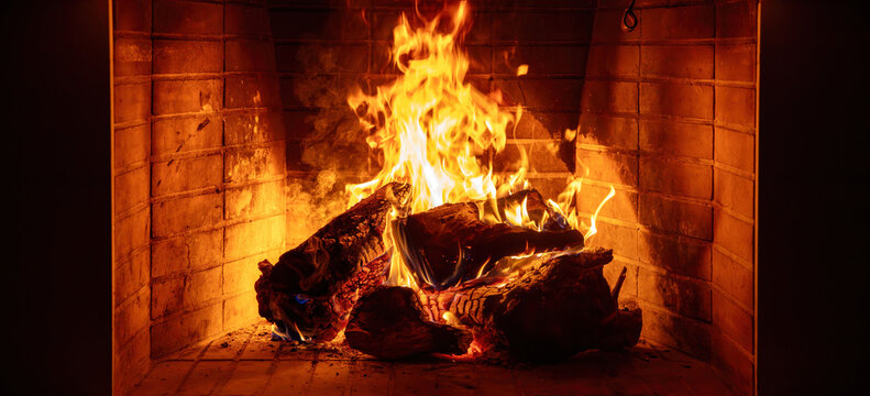 Fireplace burning wood logs. Cozy warm home in winter, Christmas holiday bonfire. Fire flames