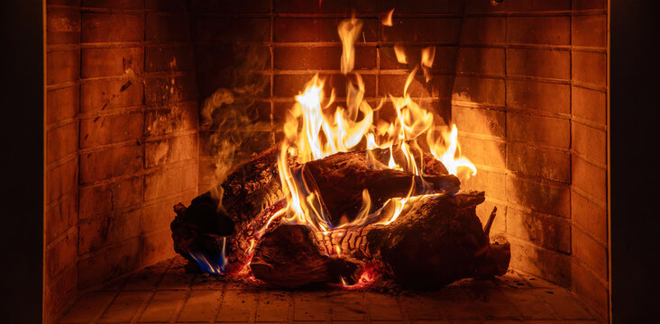 Fireplace burning wood logs. Cozy warm home in winter, Christmas holiday bonfire. Fire flames