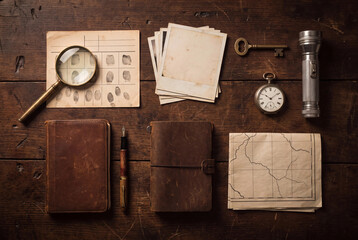 Obraz premium Detective desk photo with notebook magnifier fingerprints vintage watch and map