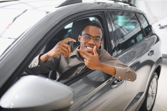 Happy african american man showing the key of his new car