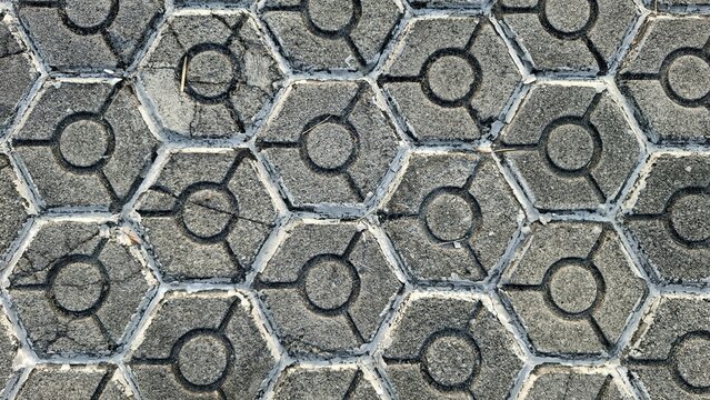 Top view of concrete hexagonal paving blocks walkway texture with circular geometric patterns.