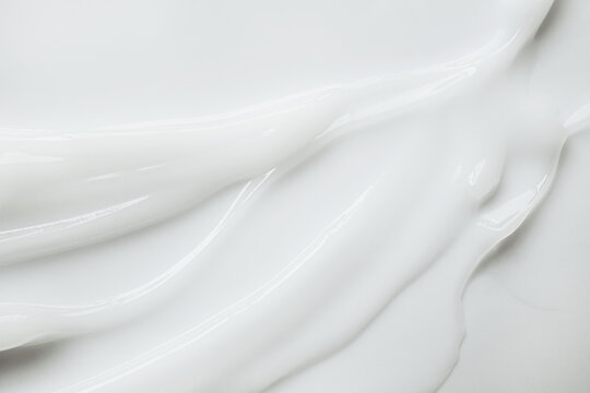 White lotion or cosmetic moisturizer spreading with smooth wavy texture