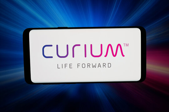 Stuttgart, Germany - 07-08-2026: In this photo illustration, the logo of nuclear medicine company Curium Pharma is displayed on a smartphone in front of abstract background on computer screen.