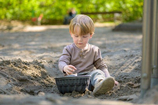 Toddler Playing Thoughtfully With Sand