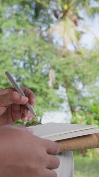 Business professional writing ideas in notebook after successful brainstorming outdoors, representing strategic planning, creative workflow, productivity, decision making, project management focused 