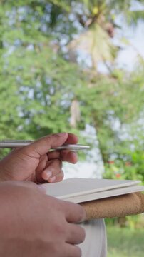 Business professional finishing handwritten notes and relaxing after completing planning outdoors as bird flies through frame, accomplishment, successful, mindful productivity, creative completion