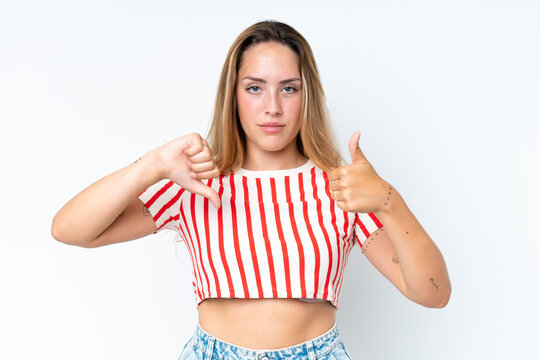 Young caucasian woman isolated on white background making good-bad sign. Undecided between yes or not