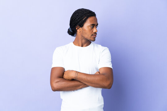 Young African American man with braids man isolated on purple background keeping the arms crossed
