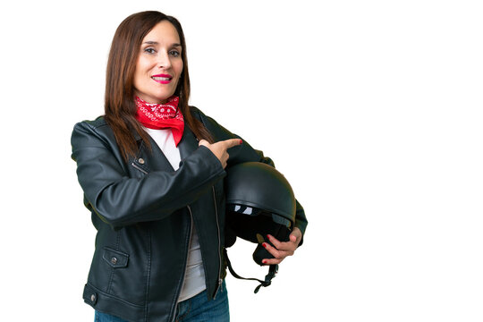 Middle age caucasian woman with a motorcycle helmet over isolated chroma key background pointing back