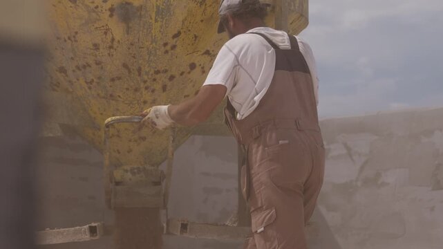 Worker unloading expanded clay aggregate for flat roof insulation