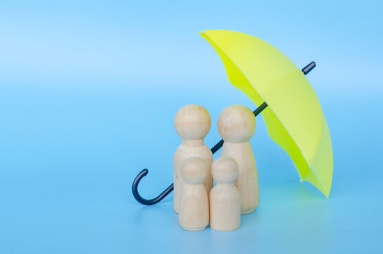 Wooden figures with a yellow umbrella representing security and insurance with customizable space for text.
